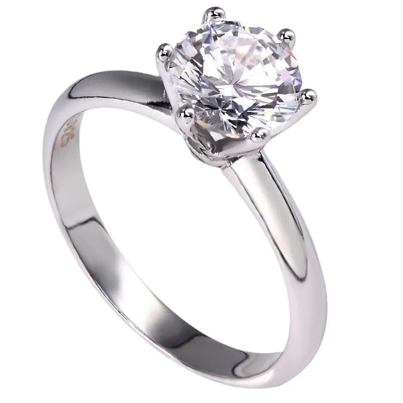 White gold plated geometric ring with a six-claw set zircon stone on a model's finger.