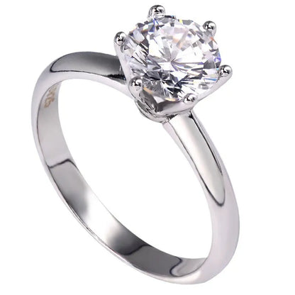 White gold plated geometric ring with a six-claw set zircon stone on a model's finger.