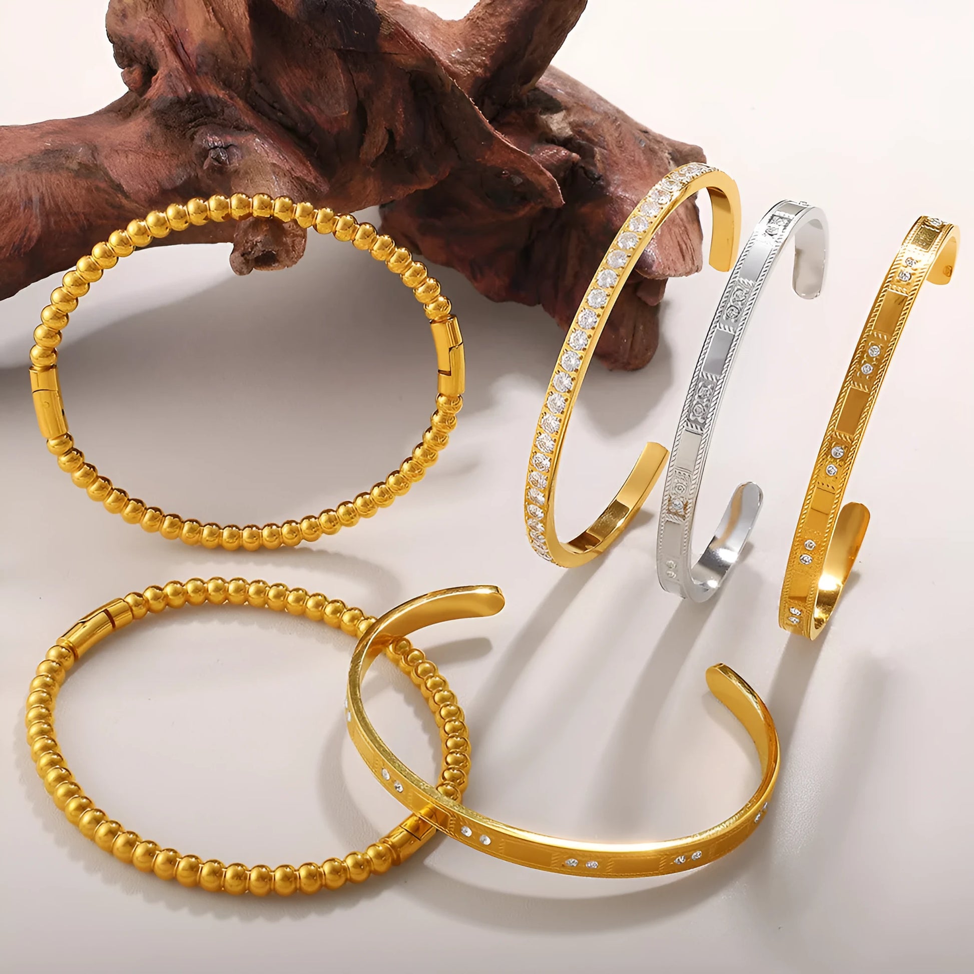Stainless steel open-end bracelet with a buckle clasp in a gold electroplated finish featuring circle design elements.