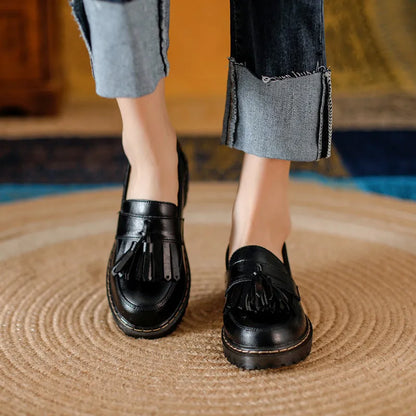 Women's brown leather loafers with tassel detail and a chunky low heel.