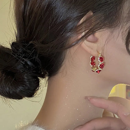 Red alloy rose flower earrings with ear clip fastening shown as complete pair