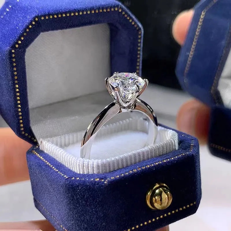 White gold plated geometric ring with a six-claw set zircon stone on a model's finger.