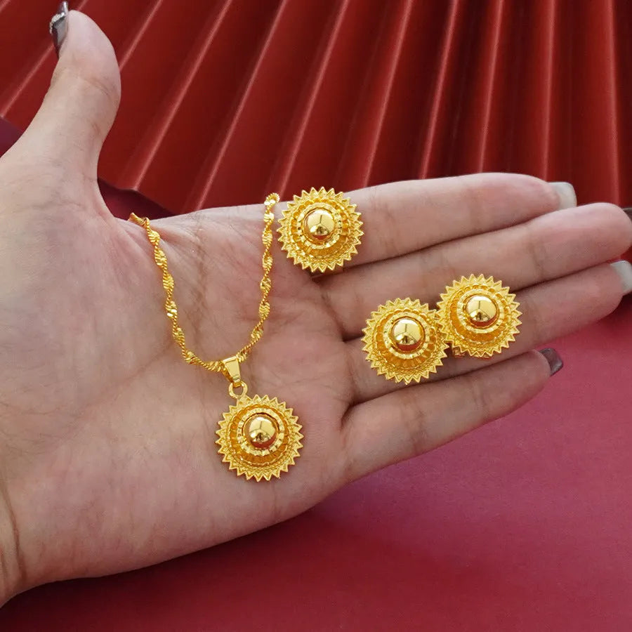 Gold-plated three-piece jewellery set with a three-layer flower design necklace, matching earrings, and ring on a white background.