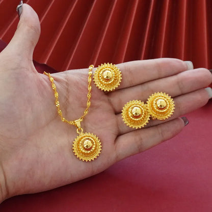 Gold-plated three-piece jewellery set with a three-layer flower design necklace, matching earrings, and ring on a white background.
