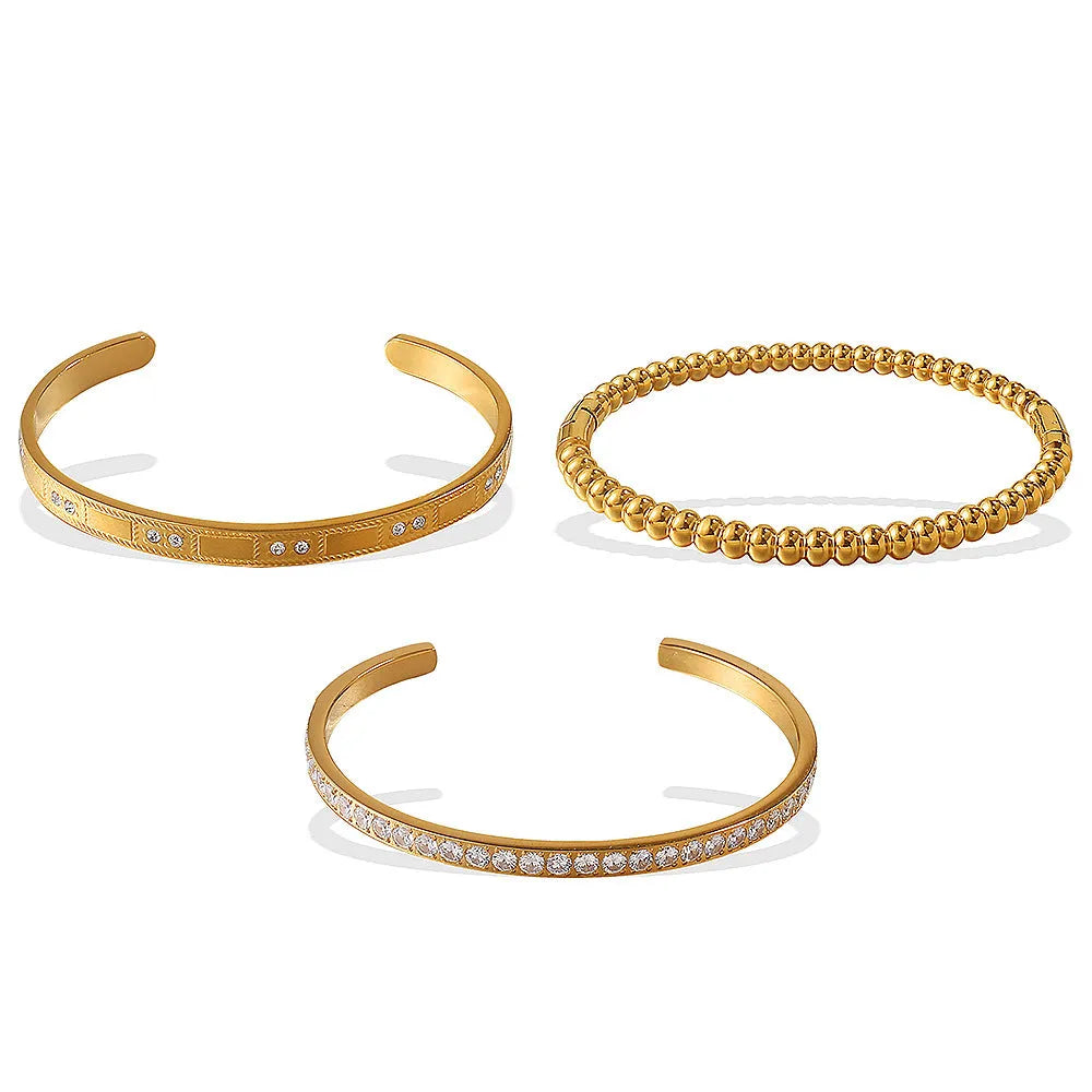 Stainless steel open-end bracelet with a buckle clasp in a gold electroplated finish featuring circle design elements.