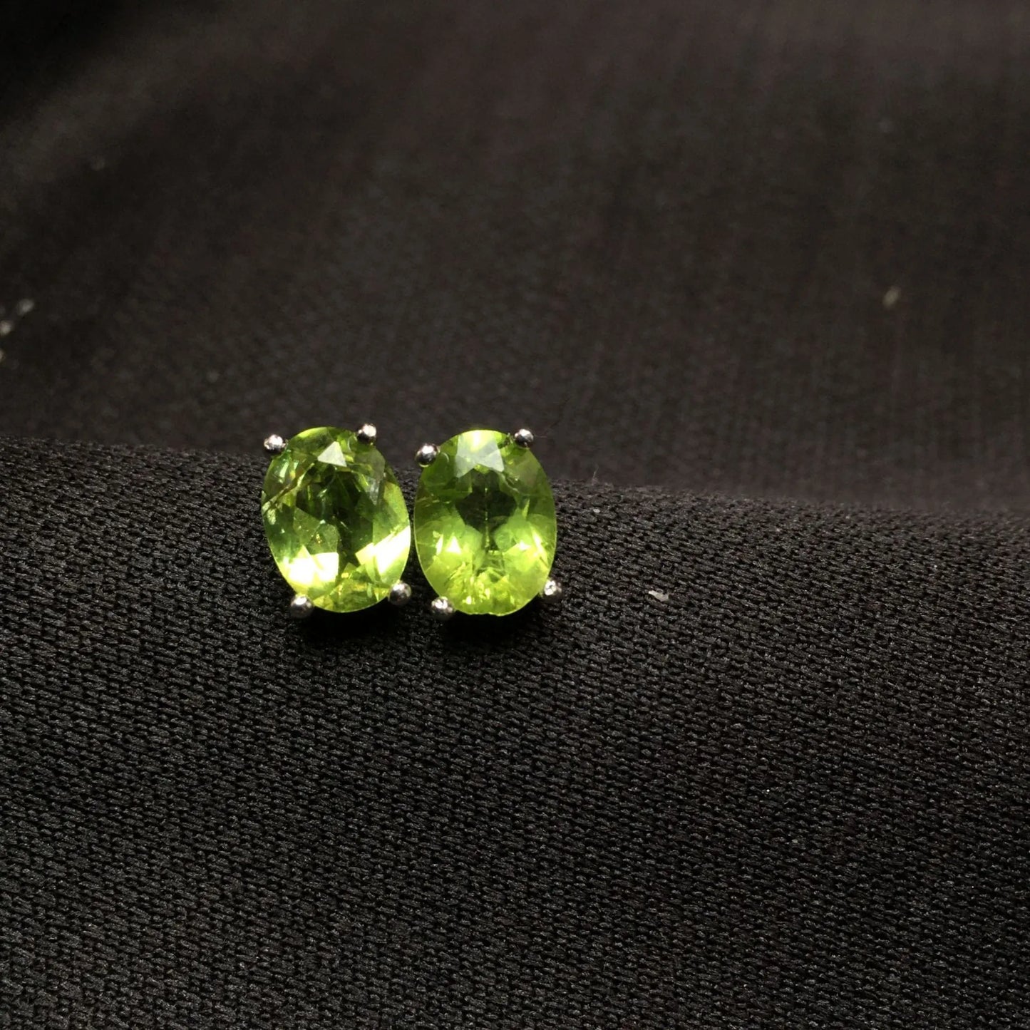 Close-up of grass green natural olivine stud earrings with geometric cut on S925 silver posts