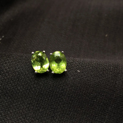 Close-up of grass green natural olivine stud earrings with geometric cut on S925 silver posts
