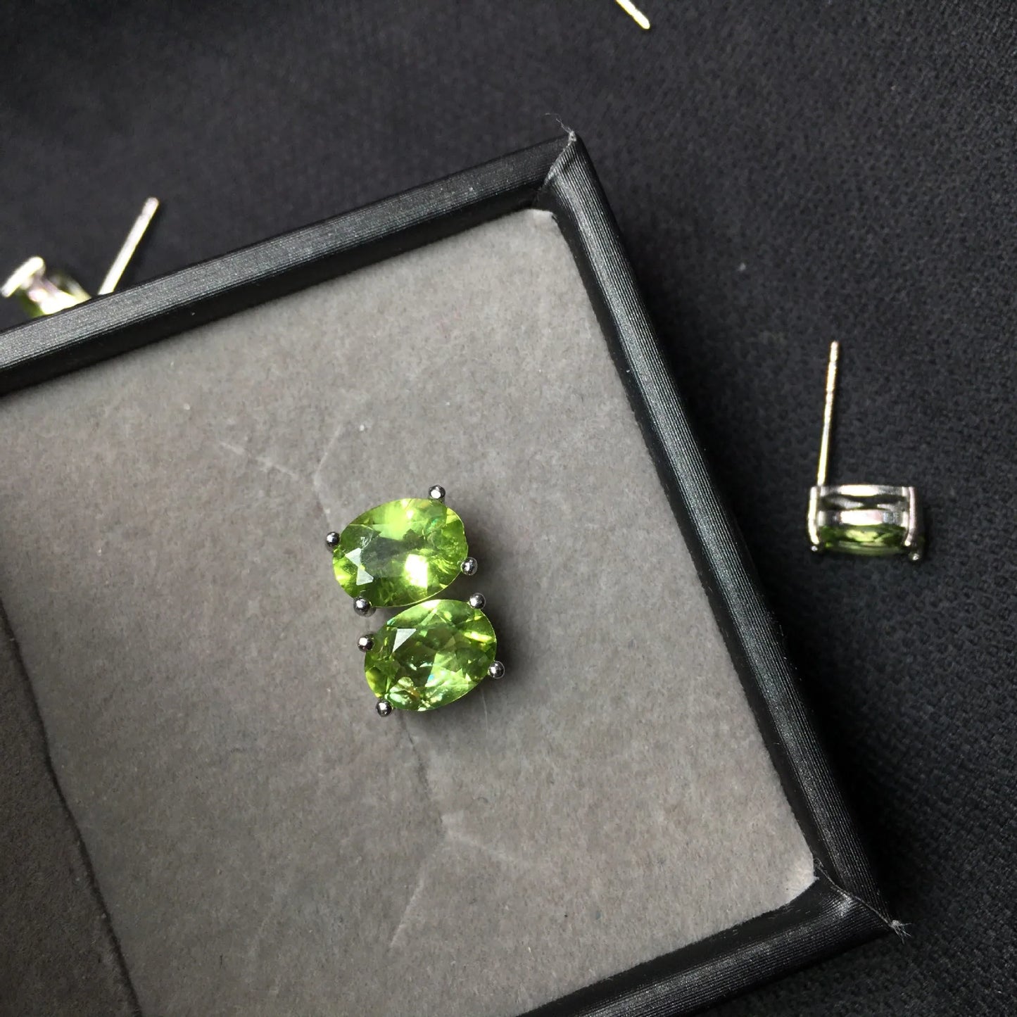 Close-up of grass green natural olivine stud earrings with geometric cut on S925 silver posts