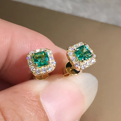 A pair of bright green square zircon stud earrings with a gold electroplated setting on a white background.
