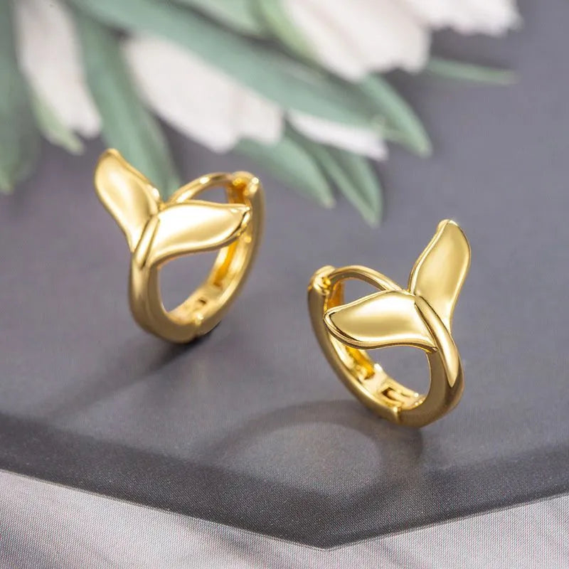 A pair of women's simple fishtail drop earrings with a gold electroplated finish on a copper base.
