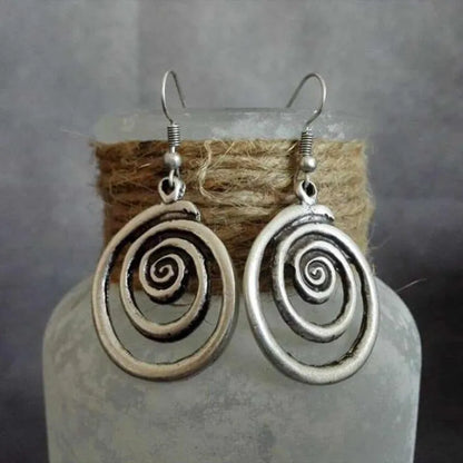 A pair of silver spiral geometric earrings with a distressed texture, shown from the front.