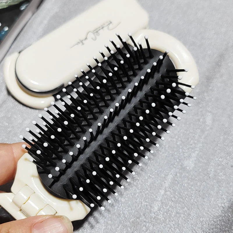 A portable, foldable hair brush with a built-in mirror for on-the-go grooming and touch-ups