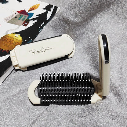 A portable, foldable hair brush with a built-in mirror for on-the-go grooming and touch-ups