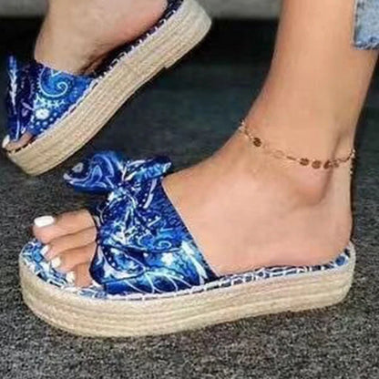 Pair of hemp straw bow slippers with satin material, available in blue, black, and pink colors