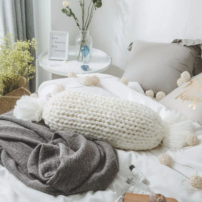 Soft and fluffy white chunky knit pillow in the shape of a candy with a kawaii tassel design, perfect for adding a playful touch to your home decor.