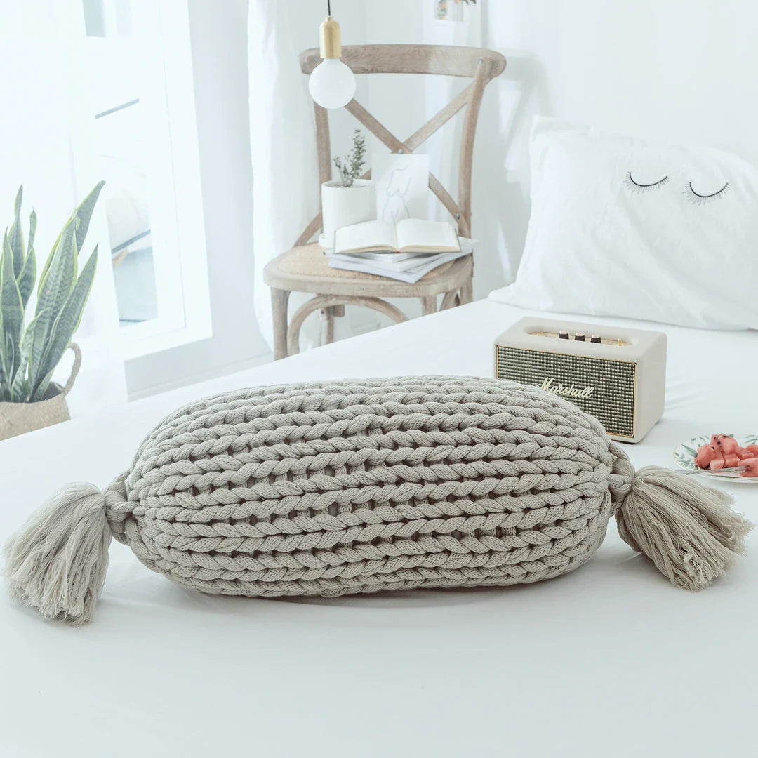 Soft and fluffy white chunky knit pillow in the shape of a candy with a kawaii tassel design, perfect for adding a playful touch to your home decor.