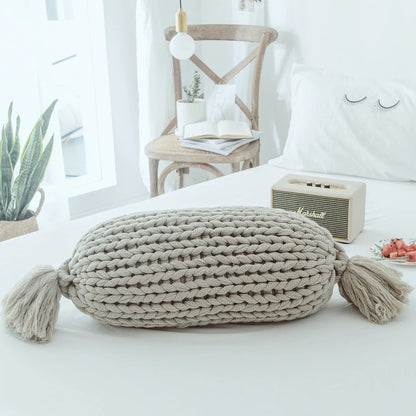 Soft and fluffy white chunky knit pillow in the shape of a candy with a kawaii tassel design, perfect for adding a playful touch to your home decor.