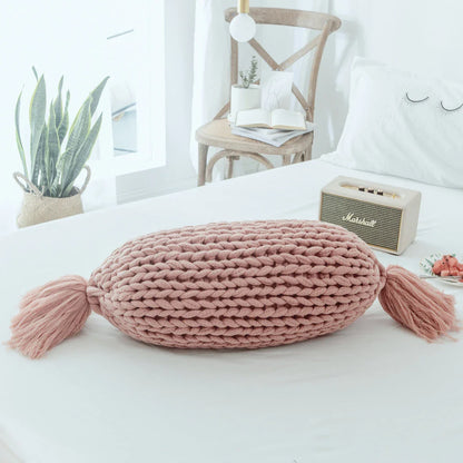 Soft and fluffy white chunky knit pillow in the shape of a candy with a kawaii tassel design, perfect for adding a playful touch to your home decor.