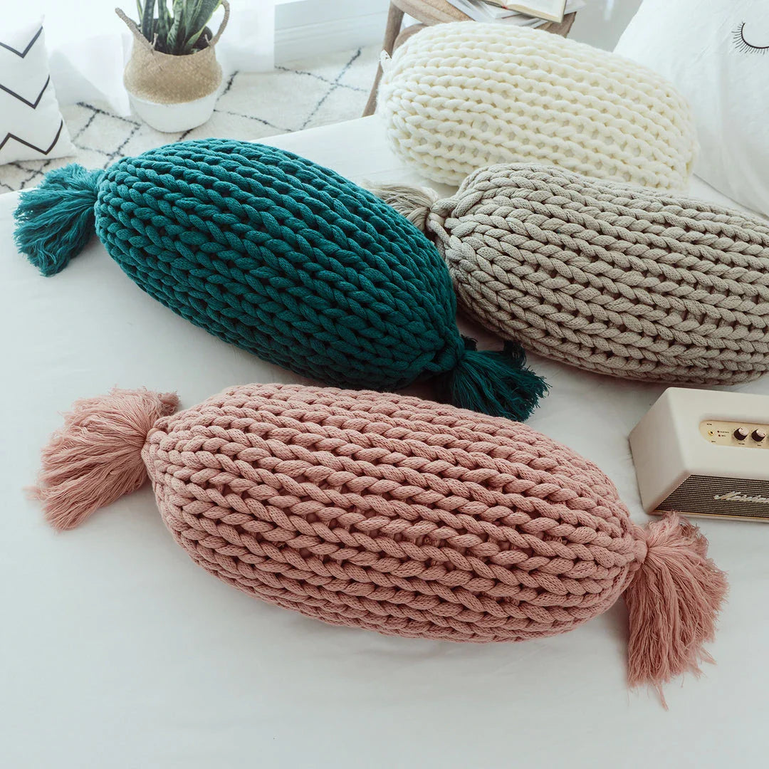 Soft and fluffy white chunky knit pillow in the shape of a candy with a kawaii tassel design, perfect for adding a playful touch to your home decor.