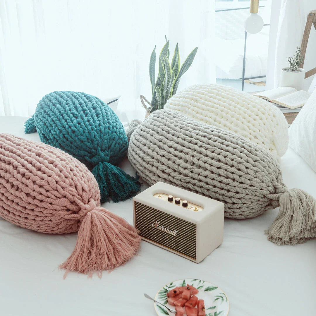 Soft and fluffy white chunky knit pillow in the shape of a candy with a kawaii tassel design, perfect for adding a playful touch to your home decor.