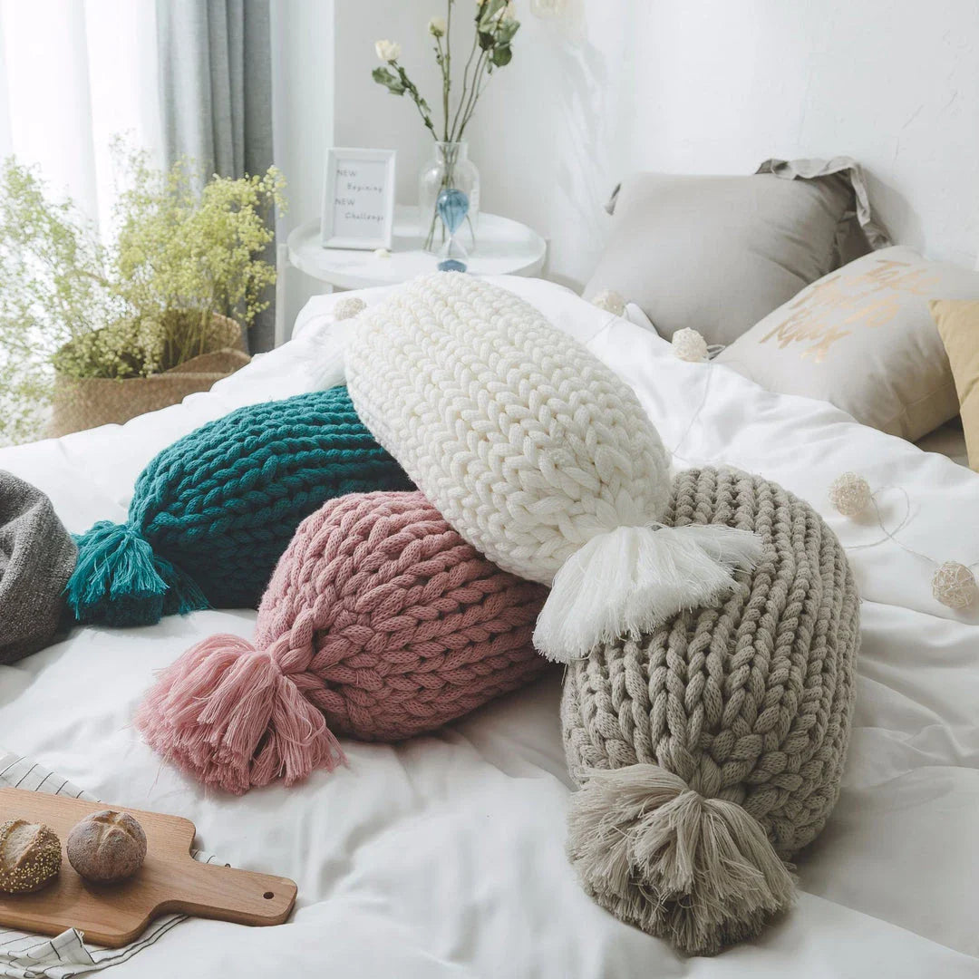 Soft and fluffy white chunky knit pillow in the shape of a candy with a kawaii tassel design, perfect for adding a playful touch to your home decor.
