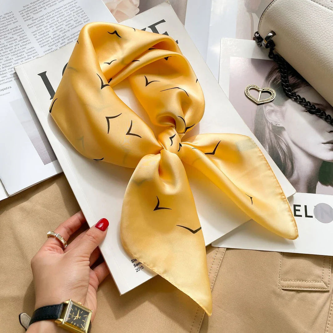 Chic Silk Square Scarf in orange color with whimsical cat print design, a luxurious and versatile fashion accessory.