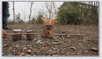 Portable titanium camping stove with folding design and open flame for cooking with natural fuels in the outdoors