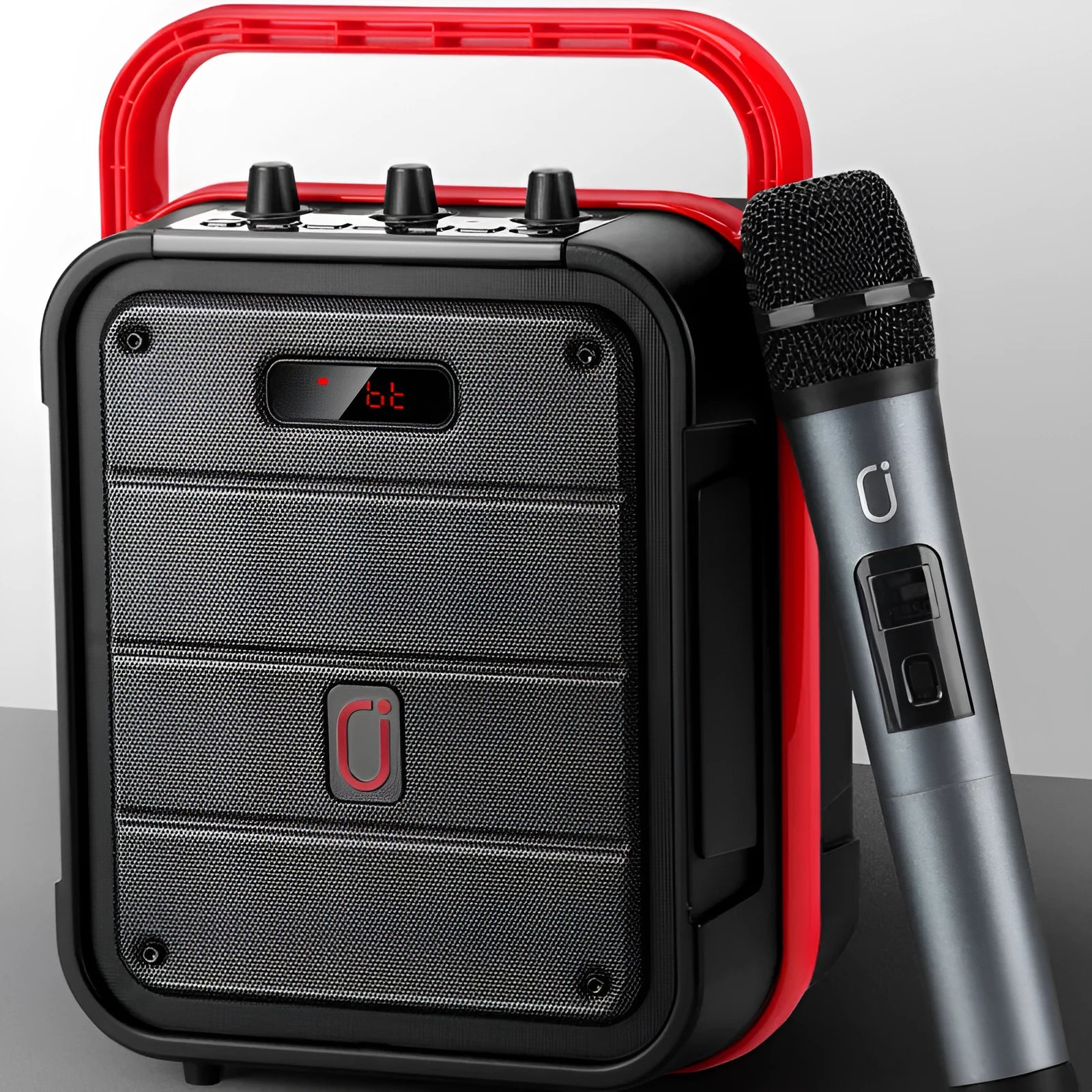 MS62AI portable Bluetooth speaker with wireless microphone on a table, showing control knob and carry strap.