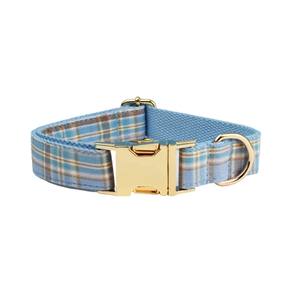 Sky blue grid pattern fabric dog collar, leash, vest, and bow set on a white background.