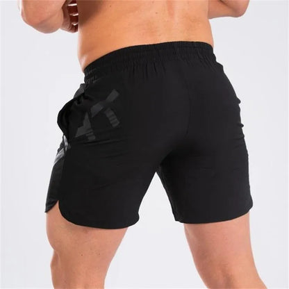 Men's black quick-dry training shorts with elastic waistband, shown knee-length.