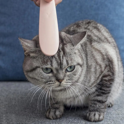 Grey and pink cat grooming comb with tongue massage design and dual-ended narrow and wide sections