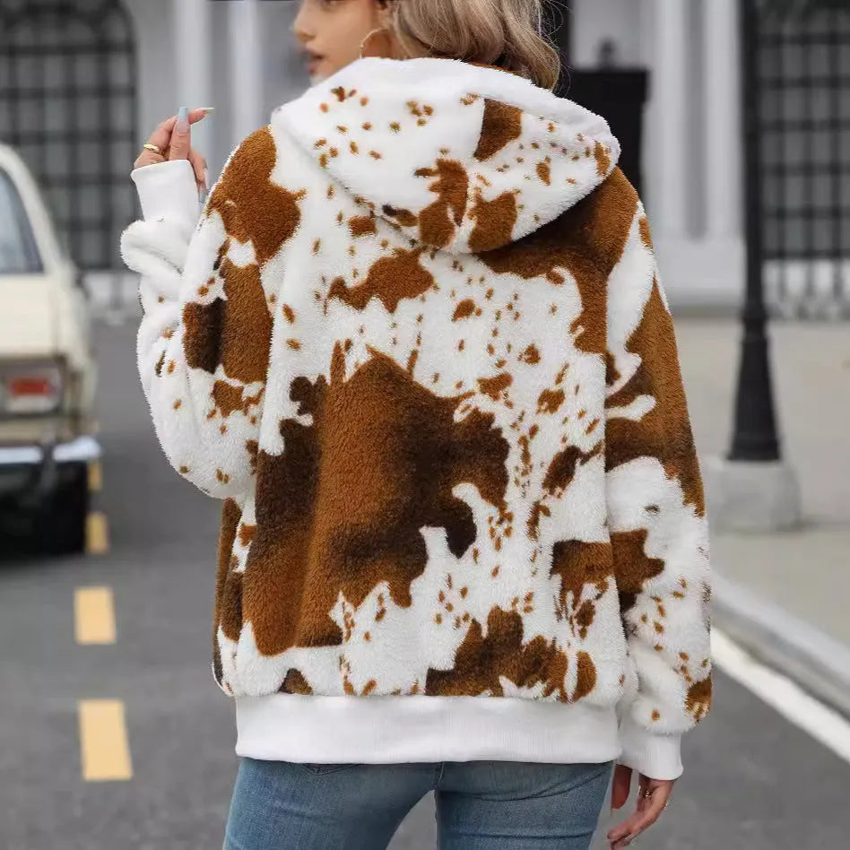 Yellow and brown cow print hooded cardigan jacket with a front zipper, shown on a model.