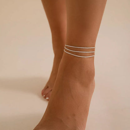 Slim chain metallic anklet in gold and white with wave design