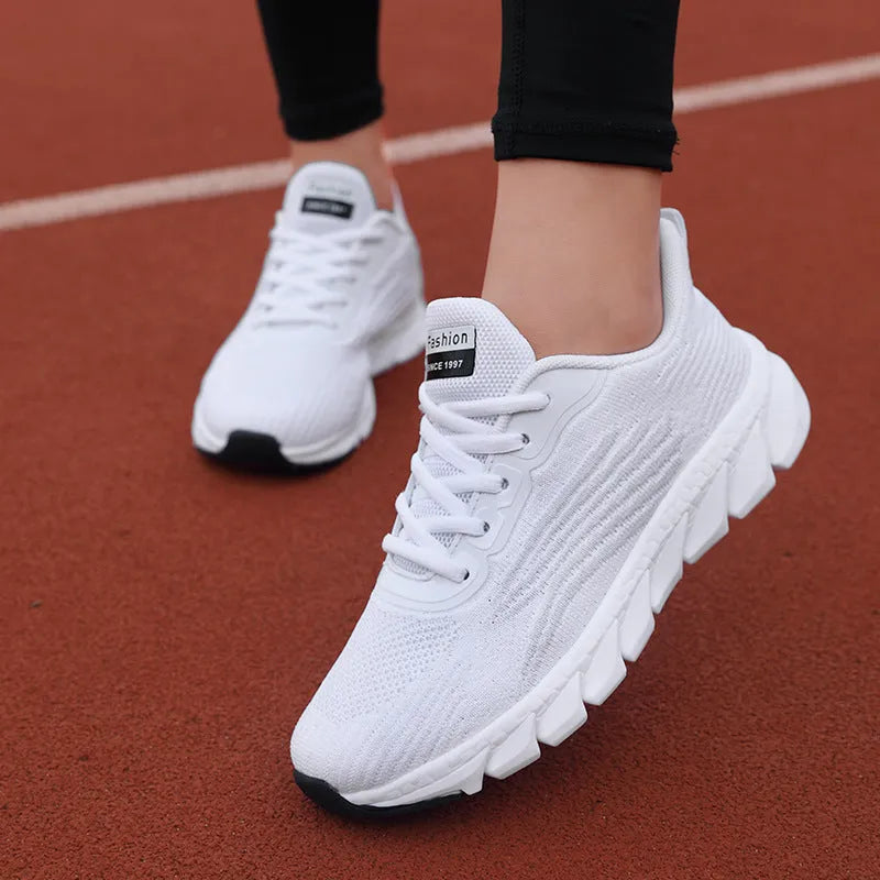 Women's black and white low-top running casual sneakers with MD sole and cross strap detail