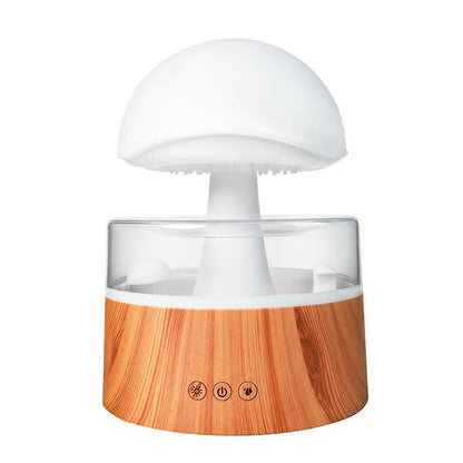 White rain cloud humidifier with falling water droplets and coloured LED lights on nightstand