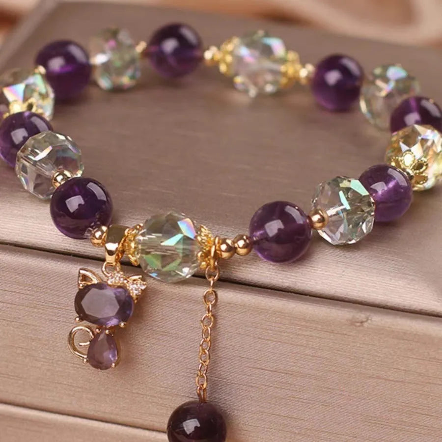 Natural purple amethyst crystal bracelet with nine-tailed fox and flower pendants on wrist.