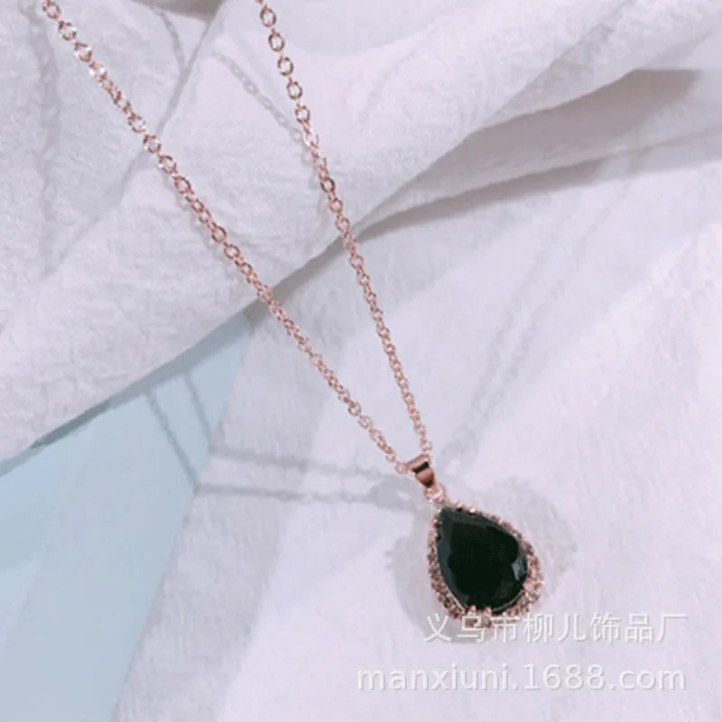 Rose gold geometric water drop pendant necklace on a model, showing adjustable chain and sparkling stone inlay.