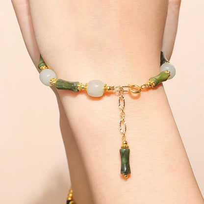 Close-up of a manually crafted crystal agate bracelet with shaped animal and fruit beads.