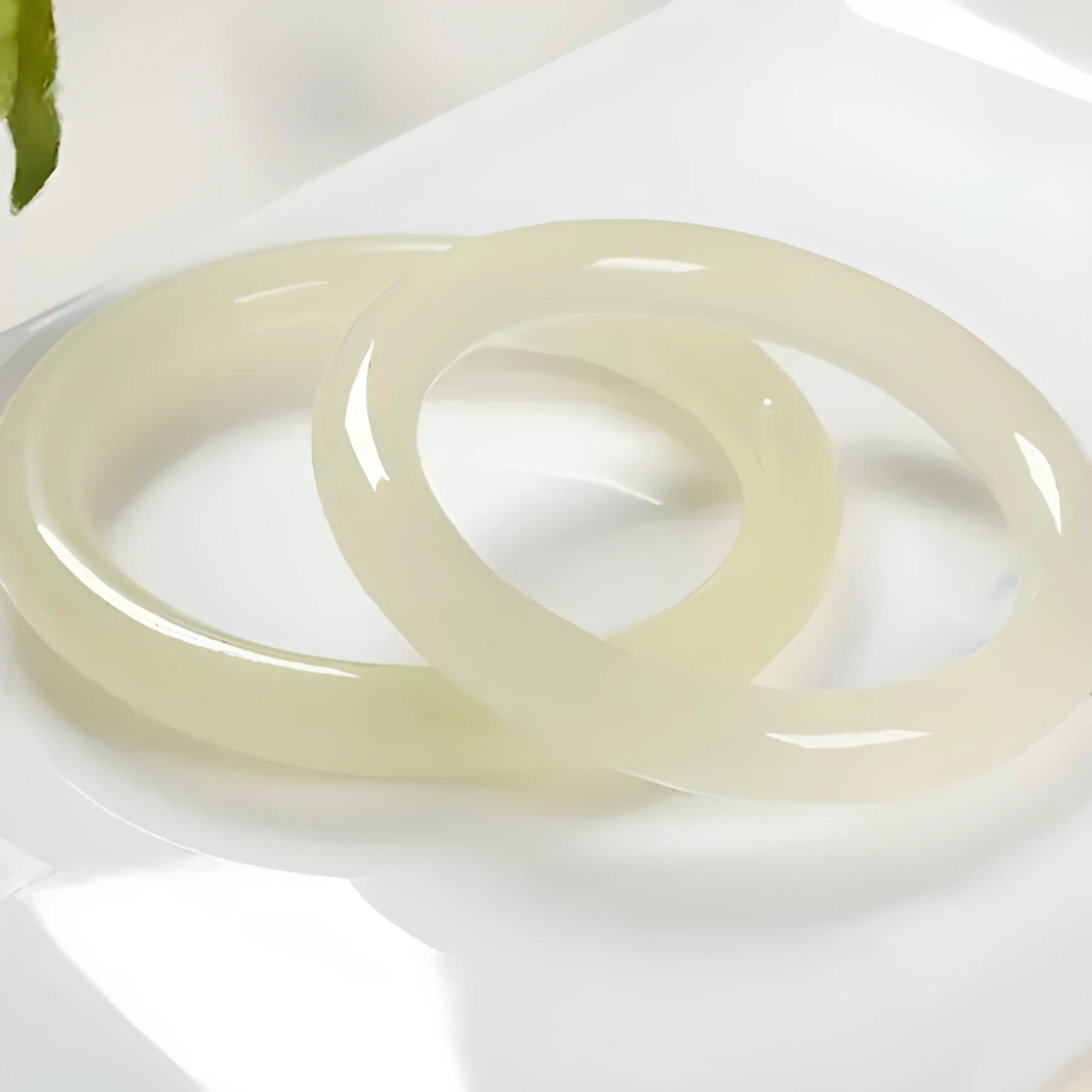 Ice-like silk jade bracelet with winding silk design and round bar beads on a wrist.