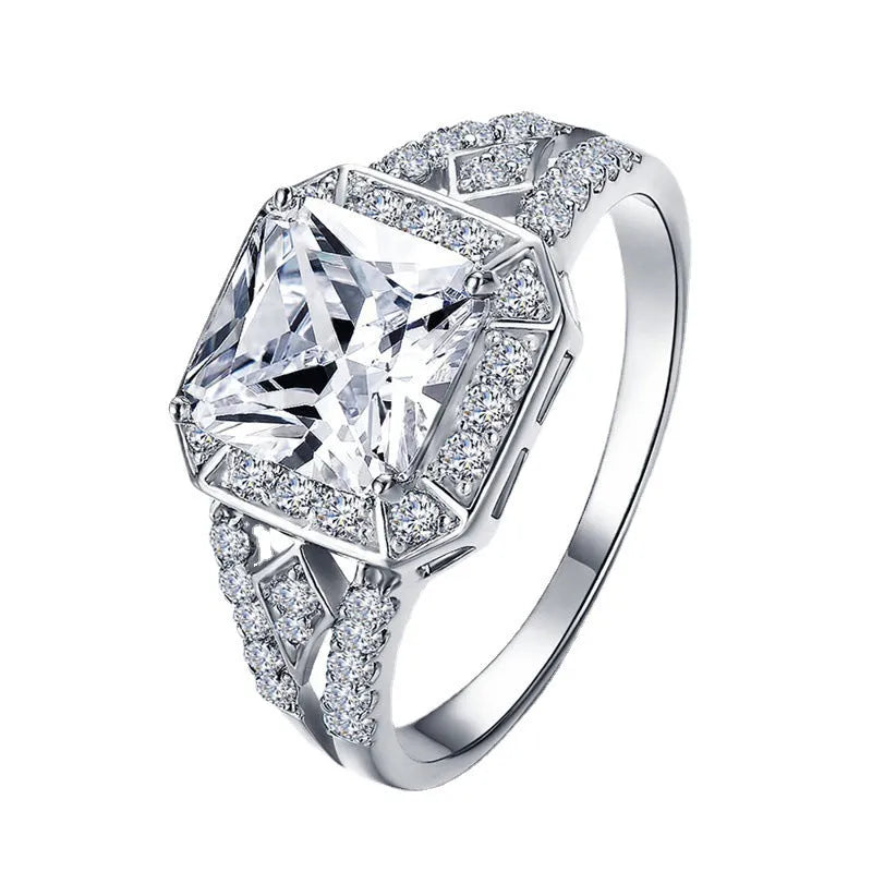 Geometric platinum-coloured copper ring with an inlaid zircon stone, showing its hollow quadrilateral design.
