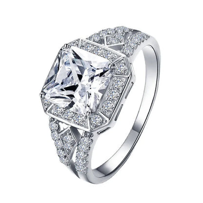 Geometric platinum-coloured copper ring with an inlaid zircon stone, showing its hollow quadrilateral design.
