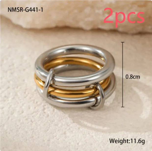 Stacked stainless steel rings with 18K gold plating in three colour variations, exaggerated hand jewellery designs