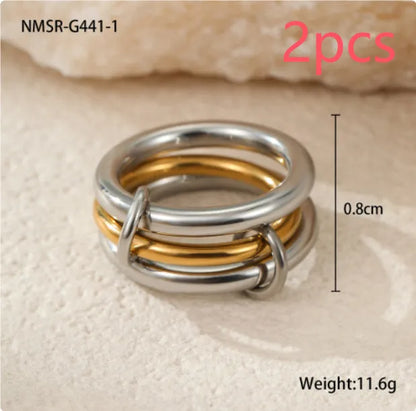 Stacked stainless steel rings with 18K gold plating in three colour variations, exaggerated hand jewellery designs