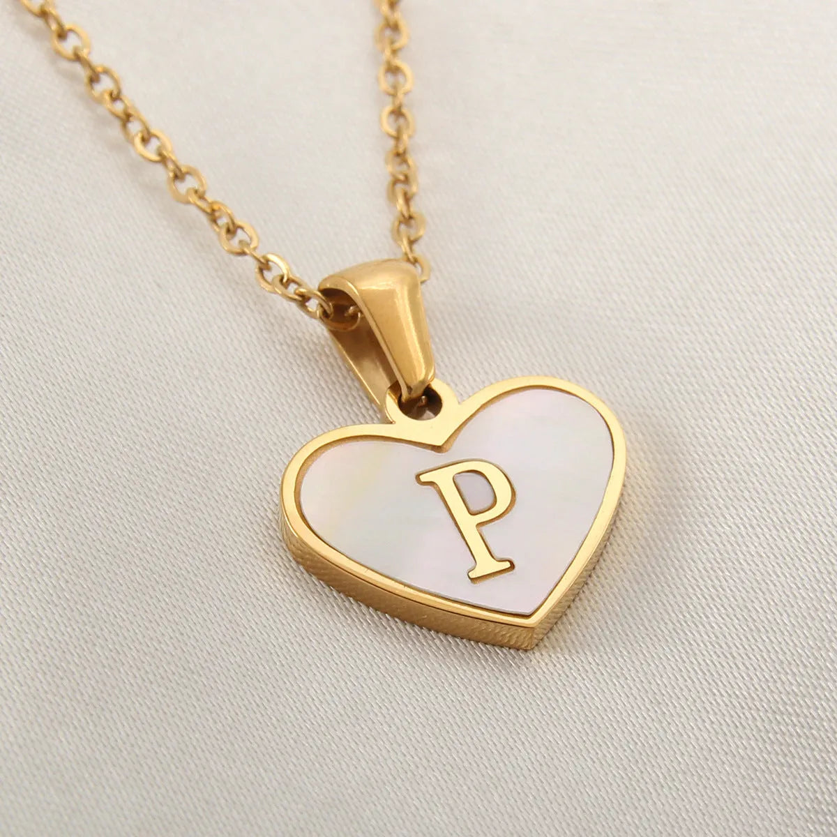 Gold-plated clavicle necklace with a white shell heart pendant, personalised with a letter from A to Z.