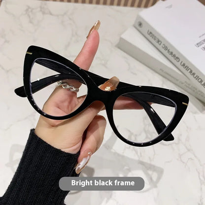 Women's black cat's eye reading glasses with gold dragon and phoenix decorations on the temples.