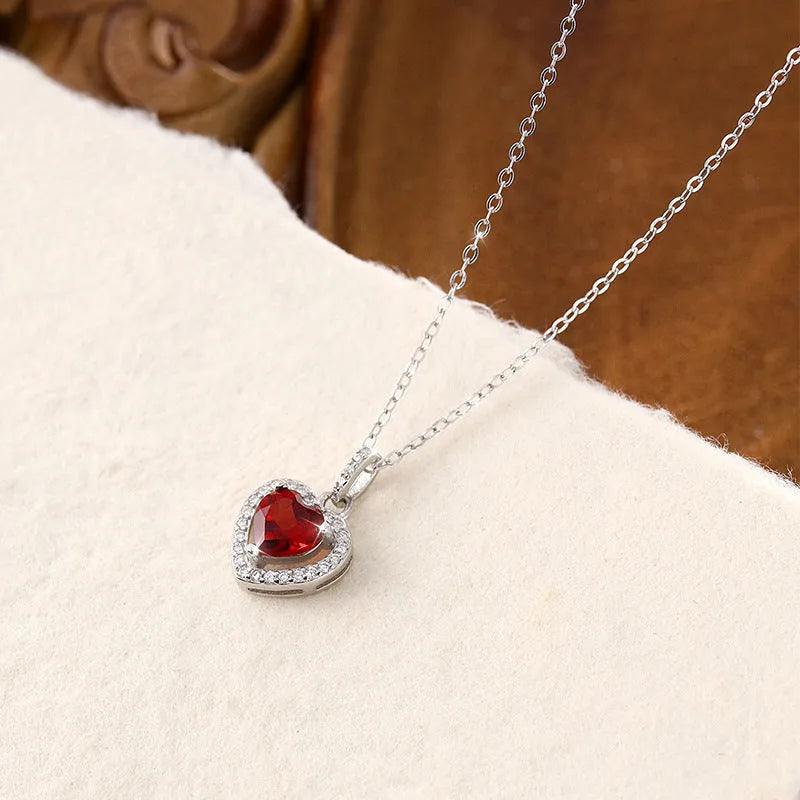 Sterling silver heart pendant necklace with a coloured gemstone on an adjustable chain.