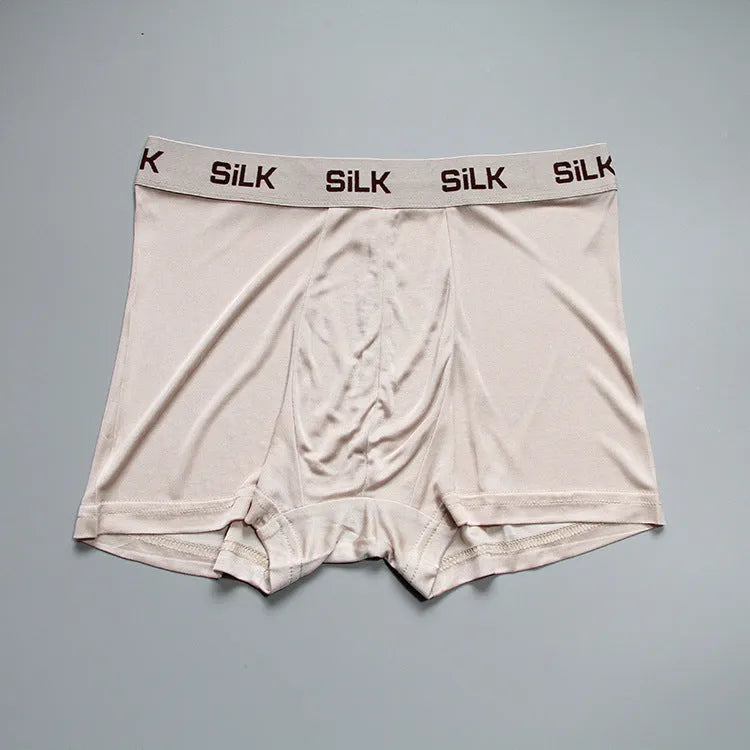 Men's loose-fitting silk shorts in navy blue on a neutral background.