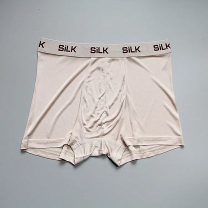 Men's loose-fitting silk shorts in navy blue on a neutral background.