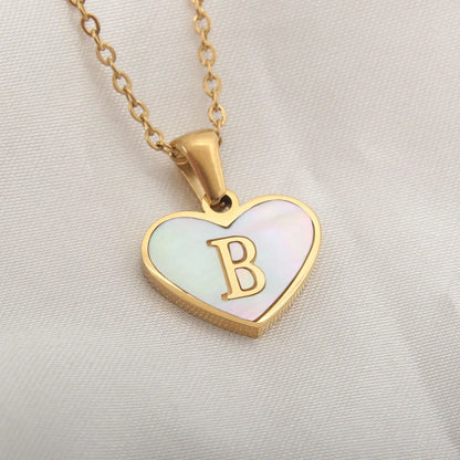 Gold-plated clavicle necklace with a white shell heart pendant, personalised with a letter from A to Z.