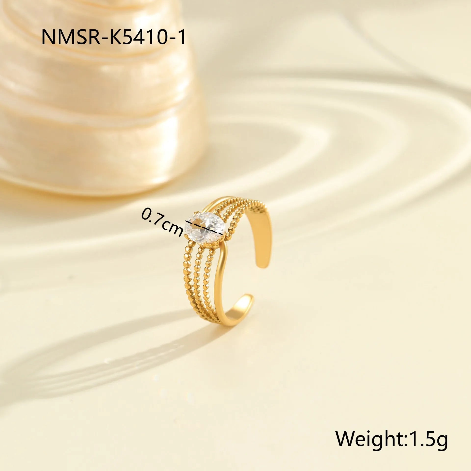 Gold electroplated stainless steel open mouth ring with geometric shapes and zircon inlay on a heart drop.